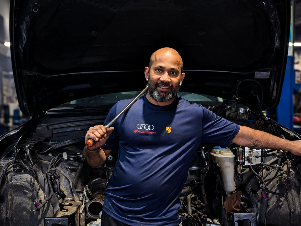 Suthan M. with an Audi engine bay at INLINE 5 AUTO INC